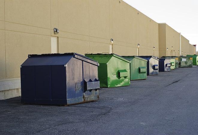 construction workers toss wood scraps into a dumpster in Broken Arrow